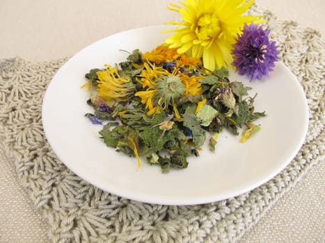 Herbal tea blend with flowers on a small plate
