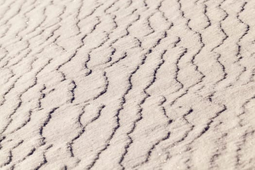 covered with white snow drifts surface. Photo closeup. On snow formed irregularities. Photo close-up, small depth of field