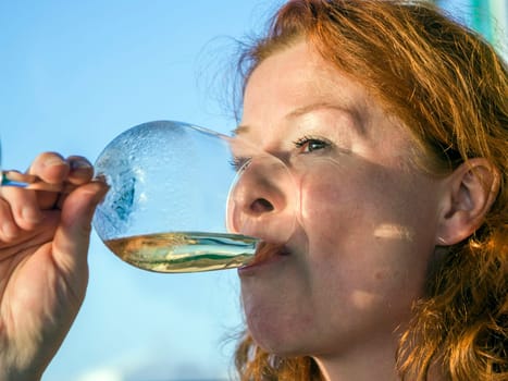 woman drinking white wine in sunset