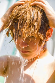 child has a refreshing shower in the garden