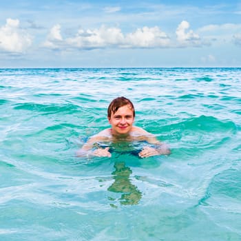 teenage boy enjoys swimming in the ocean