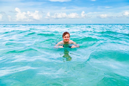 teenage boy enjoys swimming in the ocean