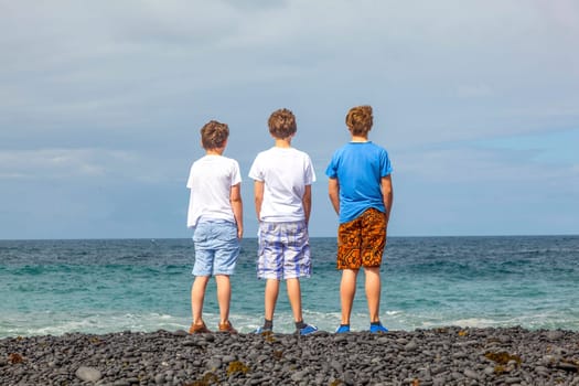 boys have fun at the black volcanic beach