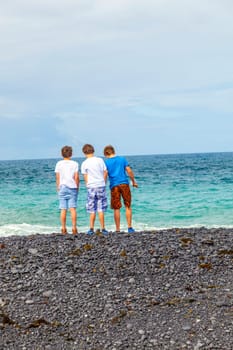 boys have fun at the black volcanic beach
