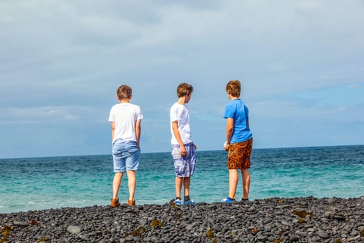boys have fun at the black volcanic beach
