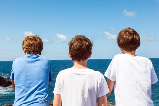 three friends watching the rocks and waves at los Hervideros in Lanzarote