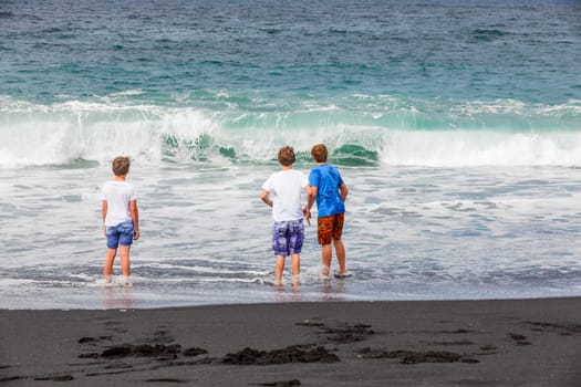 boys have fun at the black volcanic beach