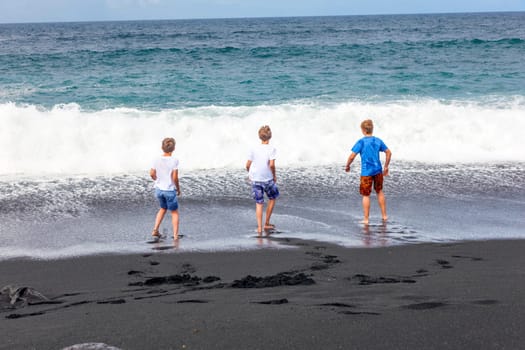 boys have fun at the black volcanic beach