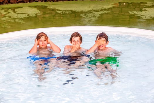 three friends in the pool imitating the three wise monkeys