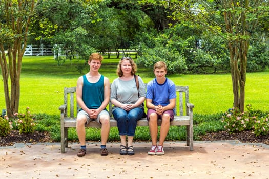 happy family sits in the garden at a bench  and enjoys the nature