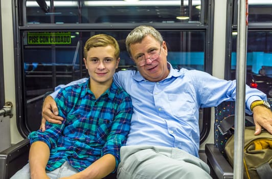 father and son at the airport bus after arrival with baggage by night