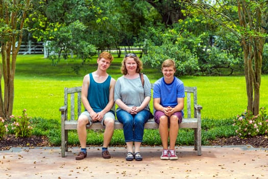 happy family sits in the garden at a bench  and enjoys the nature