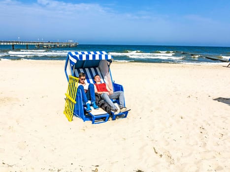 teens enjoy sunbath in the roofed wicker beach chair