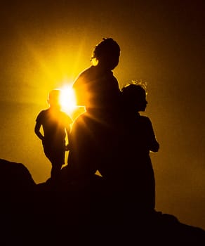 family enjoys the golden sunset on a hill