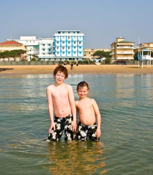 brothers in the sea at the beach of Jesolo, Venice, Italy in refreshing water