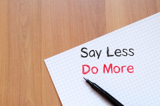 Say less do more text concept write on notebook