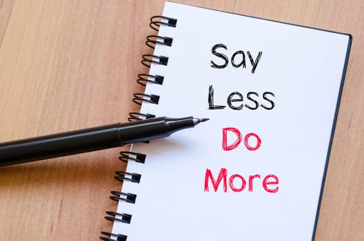 Say less do more text concept write on notebook