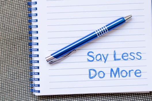 Say less do more text concept write on notebook