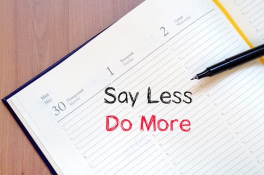 Say less do more text concept write on notebook