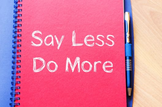 Say less do more text concept write on notebook