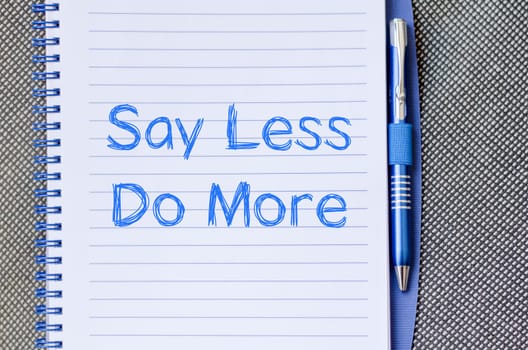 Say less do more text concept write on notebook
