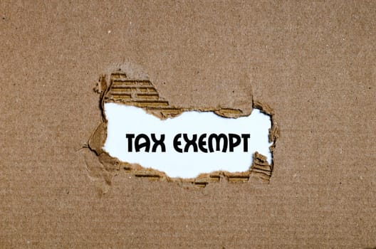 The word tax exempt appearing behind torn paper
