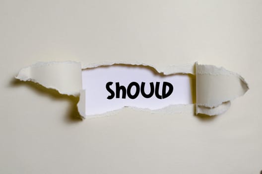 The word should appearing behind torn paper