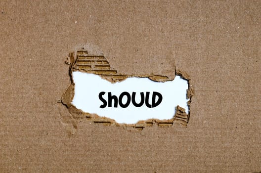 The word should appearing behind torn paper
