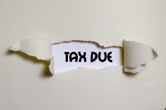 The word tax due appearing behind torn paper