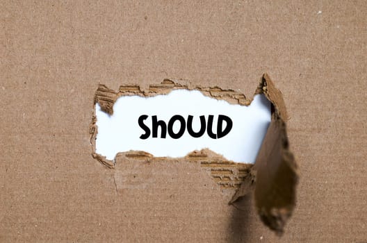 The word should appearing behind torn paper