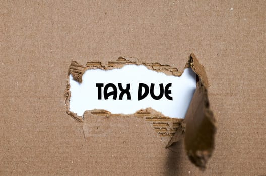 The word tax due appearing behind torn paper