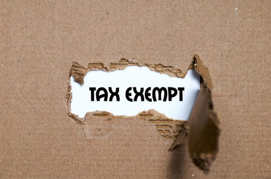 The word tax exempt appearing behind torn paper