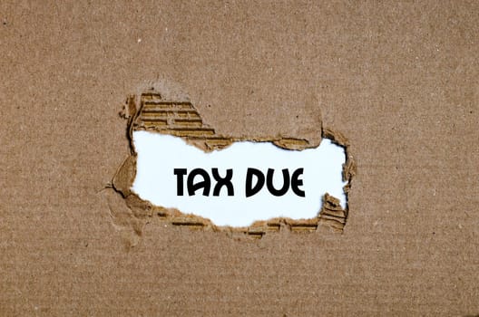 The word tax due appearing behind torn paper