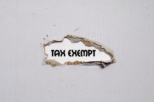 The word tax exempt appearing behind torn paper