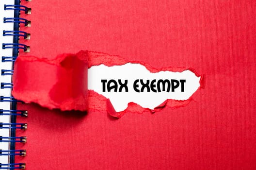 The word tax exempt appearing behind torn paper