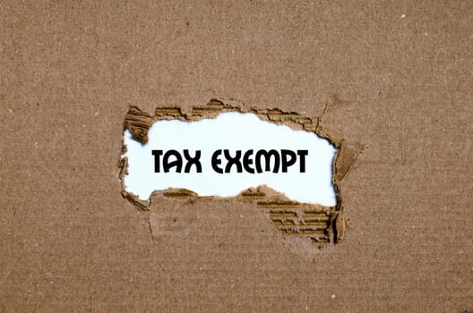 The word tax exempt appearing behind torn paper