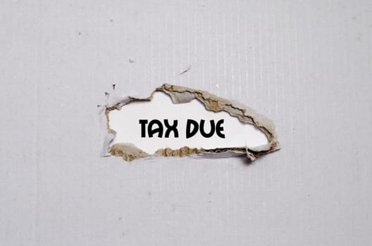 The word tax due appearing behind torn paper