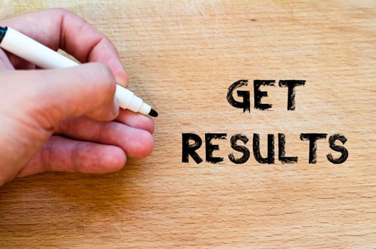Human hand over wooden background and get results text concept