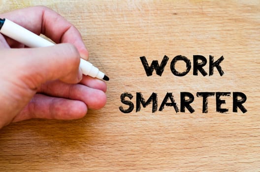Human hand over wooden background and work smarter text concept