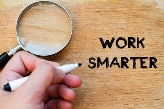 Human hand over wooden background and work smarter text concept