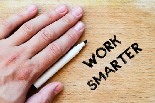 Human hand over wooden background and work smarter text concept
