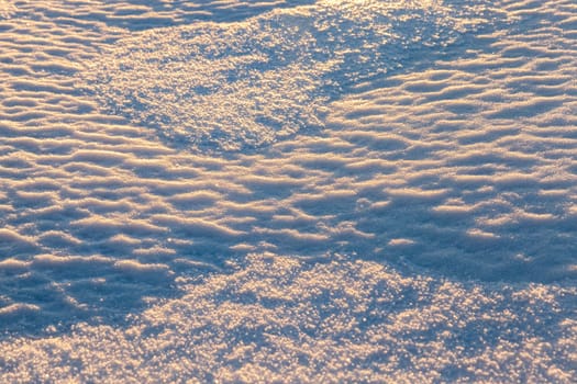 covered with white snow drifts surface. Photo closeup. On snow formed irregularities. Photo close-up, small depth of field