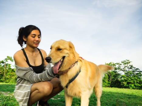 Golden retriever and Asian woman are playing in the park