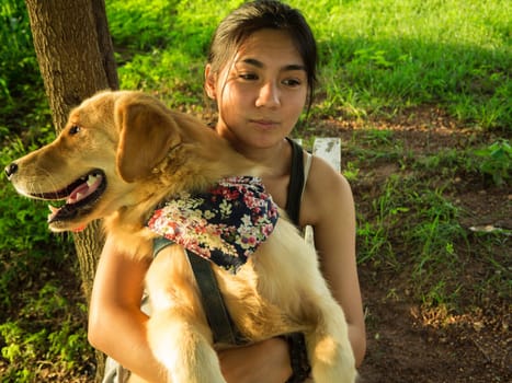 Golden retriever and Asian woman are playing in the park