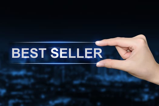 hand pushing best seller button on blurred blue background