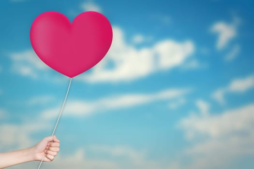 Hand Holding love Balloon with sky blurred background