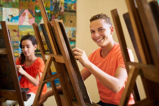School of art, college of arts, education for group of students. Portraif of happy hispanic young man smiling, looking at camera.