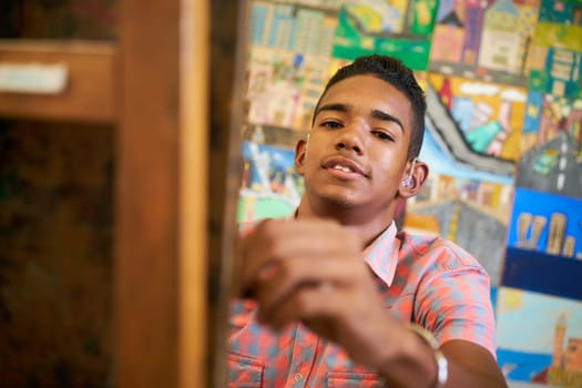School of art, college of arts. Portrait of happy black boy smiling, learning to paint and looking at camera.