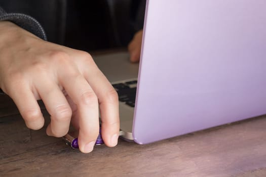 Woman using flash drive and laptop, stock photo