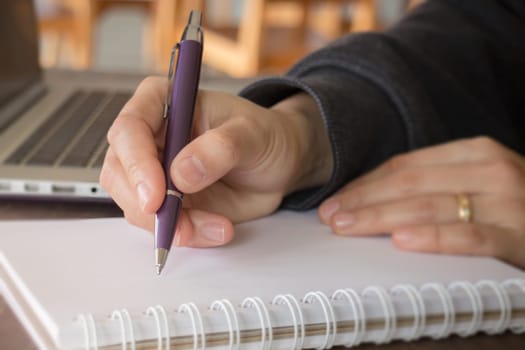 Woman hand writing on noteboook paper, stock photo